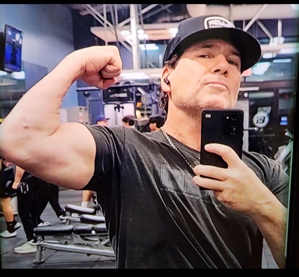 Aaron Ravo flexing in gym